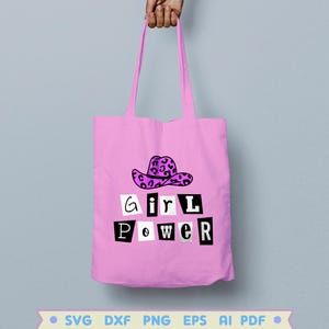 Pode incluir: Sacola de tecido rosa com um gr&aacute;fico em preto e branco que diz "girl power" e um chap&eacute;u de cowboy rosa e preto com estampa de leopardo.