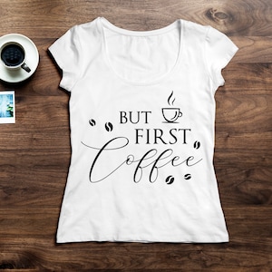 May include: White t-shirt with the text "But first, coffee" in black lettering. A coffee cup icon is above the word "first".
