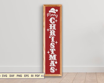 May include: A rectangular wooden sign with a red background and white text that reads "Merry Christmas." The sign features a Santa hat above the word "Merry" and decorative stars and ornaments throughout the text. The sign is framed in light brown wood.