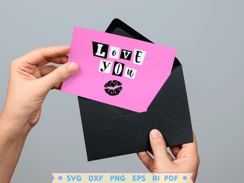Pode incluir: Cart&atilde;o rosa com as palavras "Love You" em letras pretas recortadas e uma impress&atilde;o de l&aacute;bios pretos. O cart&atilde;o est&aacute; em um envelope preto.