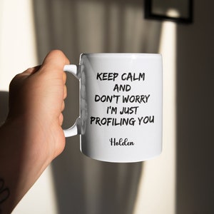 May include: White ceramic mug with black text that reads "Keep Calm and Don't Worry I'm Just Profiling You" and the name "Holden" at the bottom.