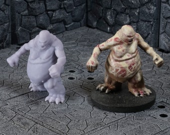 Può includere: Due miniature di creature grottesche. Una è una figura carnosa di colore pallido con una bocca spalancata e una superficie testurizzata. L'altra è una figura carnosa grigia con una bocca spalancata simile e una superficie liscia.