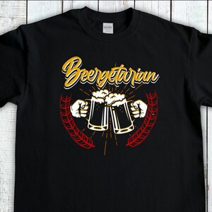 May include: Black t-shirt with the text "Beergetarian" in yellow and red lettering. Two beer mugs are shown clinking together with a wheat stalk design on either side.