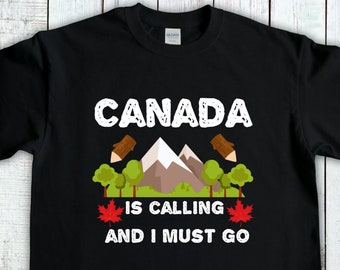 Pode incluir: Camiseta preta com texto branco que diz "CANADA IS CALLING AND I MUST GO". O design também inclui uma cordilheira estilizada, duas folhas de bordo e dois lápis.