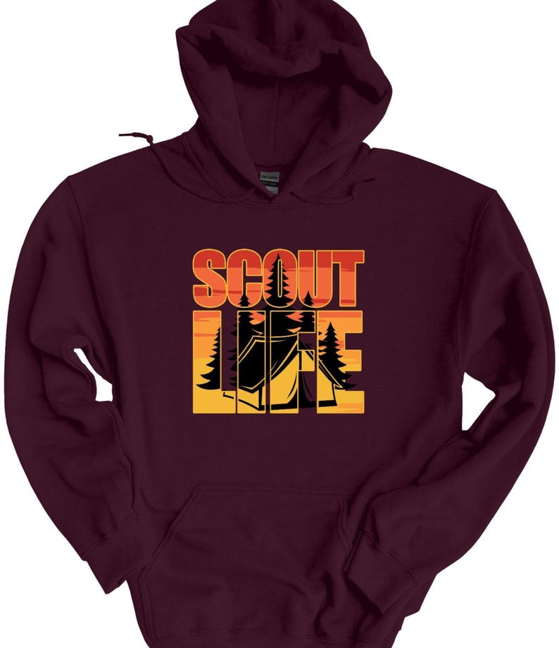May include: A maroon hooded sweatshirt with the words "SCOUT LIFE" in orange and yellow block letters. The design includes a tent and trees, suggesting a camping or outdoor theme. The sweatshirt has a front pocket and a drawstring hood.