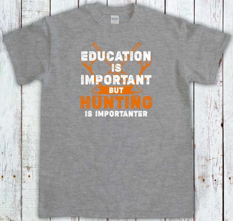 May include: A heather gray t-shirt with the text "EDUCATION IS IMPORTANT BUT HUNTING IS IMPORTER". The text is in white and orange, with crossed hunting tools above the word "HUNTING".