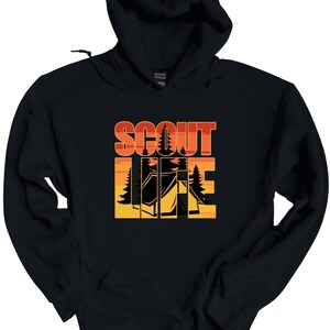 May include: Black hooded sweatshirt with the words "SCOUT LIFE" in orange and white block letters. The design includes a silhouette of a tent and trees against a sunset background. The sweatshirt has a drawstring hood.
