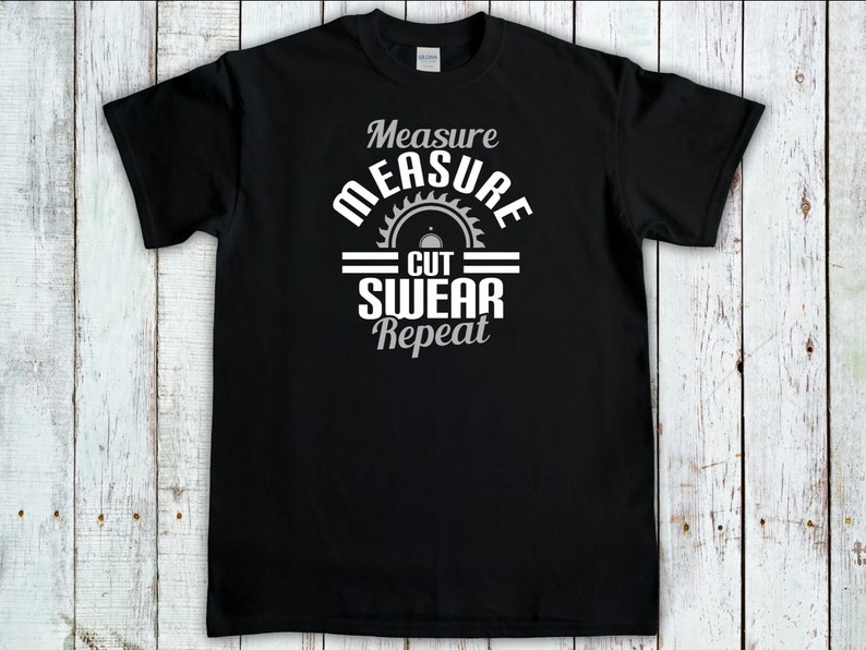May include: Black t-shirt with a white graphic design that says "Measure Cut Swear Repeat" with a saw blade icon.
