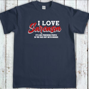 May include: A navy blue t-shirt with white text that reads "I love Sarcasm. It's like punching people in the face but with words." The text "Sarcasm" is in red.