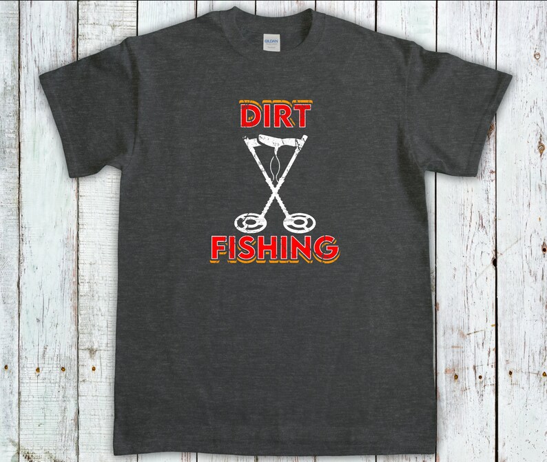 May include: Dark gray t-shirt with a white graphic of two crossed metal detectors and the text "DIRT FISHING" in red and yellow.