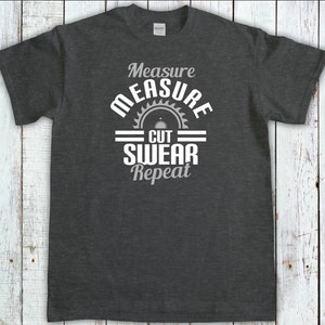May include: Dark gray t-shirt with a white graphic design that says "Measure Measure Cut Swear Repeat" with a saw blade graphic.