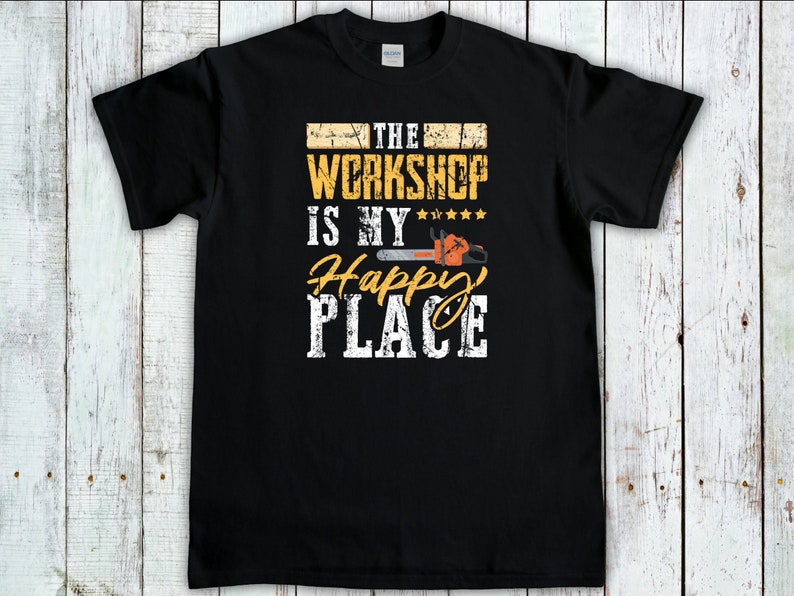 Peut inclure: T-shirt noir avec un graphisme jaune qui dit "The Workshop is my Happy Place" avec un graphique de tron&ccedil;onneuse.