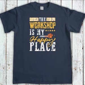 Peut inclure: Un t-shirt bleu marine avec un design graphique vieilli qui dit "The Workshop is my Happy Place" avec un graphique de tron&ccedil;onneuse.