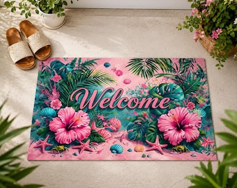 May include: A rectangular doormat featuring a vibrant tropical design with large pink hibiscus flowers, green palm leaves, and scattered seashells on a pink sandy background. The word Welcome is printed in a bold, dark pink cursive script.