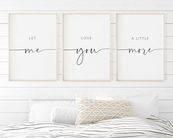 Puede incluir: Tres impresiones enmarcadas con el texto "Déjame amarte un poco más" colgadas en una pared blanca sobre una cama con un edredón de rayas blancas y grises y una manta blanca.