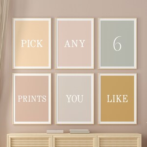 May include: Six framed prints with the words "Pick any 6 prints you like" displayed on a light brown wall above a light wood cabinet with three doors.