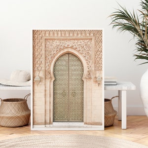 May include: A framed print of a decorative archway with a large, ornate door. The door is made of metal and has a geometric pattern. The archway is made of stone and has intricate carvings.