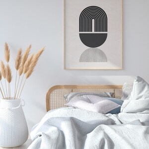 Pu&ograve; includere: Un letto bianco con una testiera in legno e un piumino bianco. Il letto &egrave; decorato con una stampa astratta in bianco e nero in una cornice di legno e un vaso di erba della pampa secca.