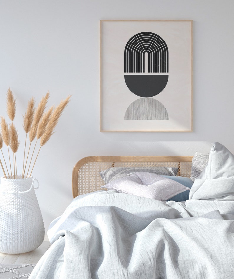 Pu&ograve; includere: Un letto bianco con una testiera in legno e un piumino bianco. Il letto &egrave; decorato con una stampa astratta in bianco e nero in una cornice di legno e un vaso di erba della pampa secca.