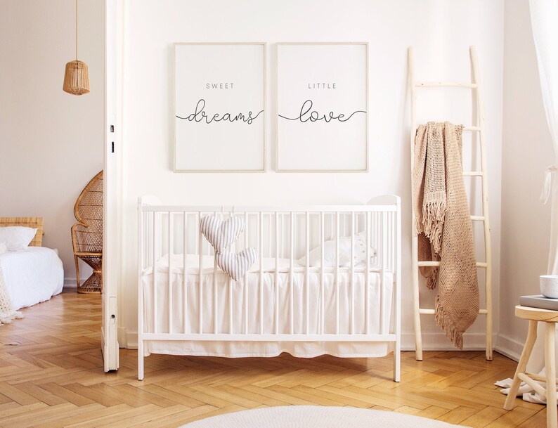 Puede incluir: Dos impresiones enmarcadas blancas con caligraf&iacute;a negra en una pared blanca. La impresi&oacute;n de la izquierda dice "Sweet Dreams" y la impresi&oacute;n de la derecha dice "Little Love". Una cuna blanca con un volante blanco y una almohada en forma de coraz&oacute;n gris y blanco est&aacute; en primer plano.