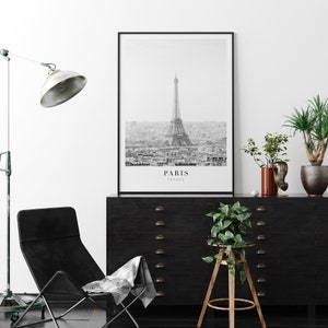 Peut inclure: Photographie en noir et blanc de la tour Eiffel &agrave; Paris, France. La photo montre la tour de loin, avec l'horizon de la ville en arri&egrave;re-plan. Le texte "PARIS FRANCE" est imprim&eacute; sous l'image.