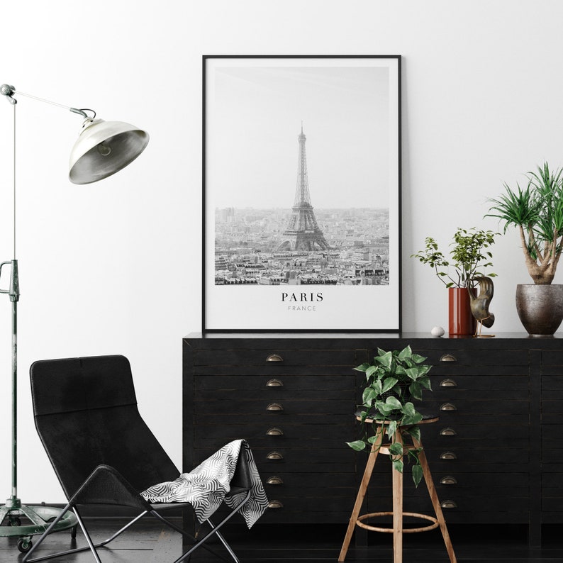 Peut inclure: Photographie en noir et blanc de la tour Eiffel &agrave; Paris, France. La photo montre la tour de loin, avec l'horizon de la ville en arri&egrave;re-plan. Le texte "PARIS FRANCE" est imprim&eacute; sous l'image.