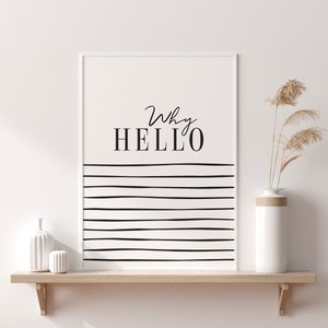 May include: A white framed print with black text that reads "Why HELLO" and black horizontal lines. The print is on a wooden shelf with a white vase and dried pampas grass.