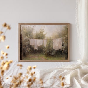 May include: A painting of a clothesline with white linens hanging in a lush green forest setting. The painting has a soft, dreamy feel and evokes a sense of peace and tranquility.