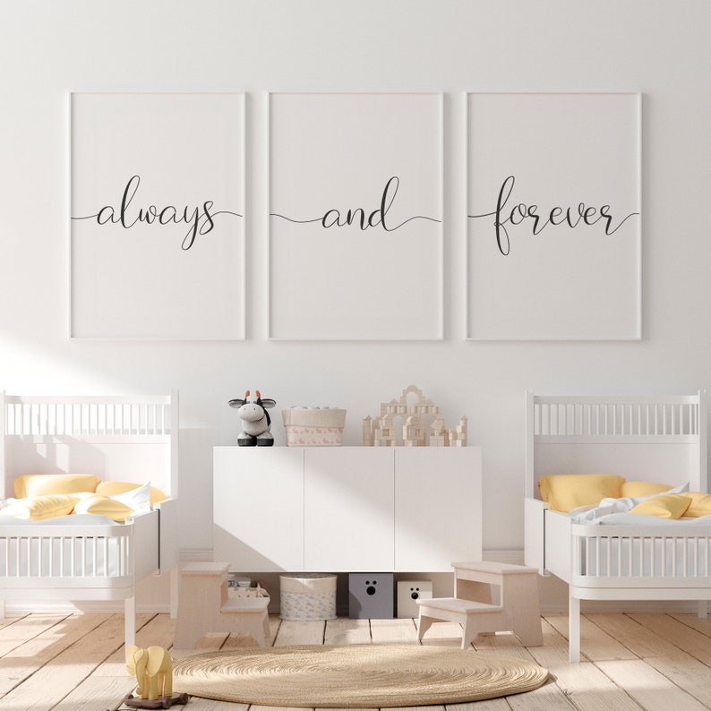 May include: Three white framed prints with black calligraphy that reads "always", "and", and "forever". The prints are hanging on a white wall above a white dresser with two white cribs on either side.