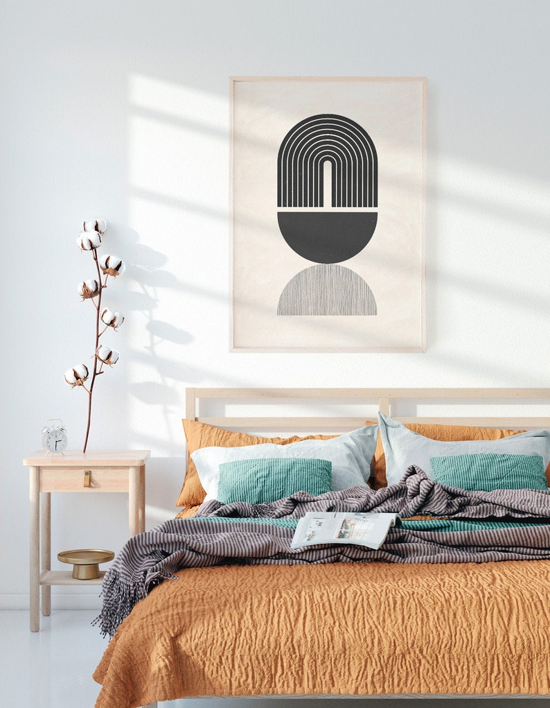 Pu&ograve; includere: Una camera da letto con un letto con una coperta a righe marroni e grigie e un cuscino turchese. Una stampa incorniciata con un design geometrico in bianco e nero &egrave; appesa sopra il letto.