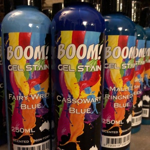 May include: Three bottles of blue gel stain with colorful labels. The labels say "BOOM! Gel Stain" and feature different shades of blue with the names "Fairy Wren Blue", "Cassowary Blue", and "Mallee Ringneck Blue". Each bottle is 250 ml and is scented and non-toxic.