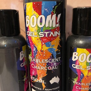 May include: Two bottles of pearlescent charcoal gel stain. The larger bottle is 250 ml and the smaller bottle is 100 ml. Both bottles have a black and white label with the text "BOOM! Gel Stain" and "Pearlescent Charcoal".