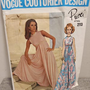 May include: Vintage Vogue Couturier Design sewing pattern by Pucci of Italy, featuring a woman in a pink dress and a drawing of a patterned dress. The pattern number is 2113.