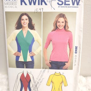May include: A sewing pattern package featuring two women modeling tops. The package includes a long-sleeved top with color-blocked panels in yellow, green, and blue, and a pink turtleneck top. The package also shows diagrams of the top designs.