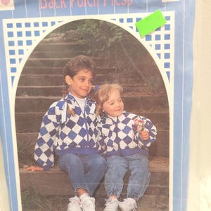 May include: A blue and white diamond-patterned jacket with matching pants. The jacket is worn by two children sitting on steps. The text "Back Porch Press" is at the top of the image. The text "CHILD'S HEART WARMING JACKET" is at the bottom.
