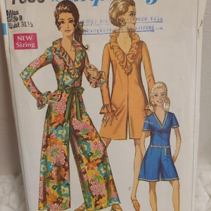 May include: A vintage Simplicity sewing pattern with illustrations of three outfits: a floral jumpsuit, an orange coat, and a blue romper. The pattern is for Misses size 8 with a bust of 80 cm. The pattern is marked as 'New Sizing'.