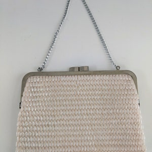 May include: A white beaded clutch bag with a silver chain strap.