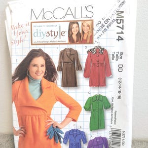 May include: A McCall's DIY style sewing pattern, M5714, featuring a woman in an orange jacket. The pattern includes designs for various coats in brown, red, green, blue, and purple. The size is DD (12-14-16-18).