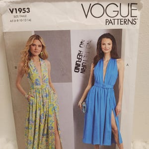 May include: Vogue Patterns sewing pattern V1953. The pattern features two halter-neck dresses with high slits. One dress is a blue solid colour, and the other is a yellow and green floral print. The pattern size is A5 (6-8-10-12-14).