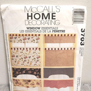 May include: A McCall's Home Decorating pattern envelope showing different window treatment designs. The designs include floral, striped, and geometric patterns in various colours. The text "WINDOW ESSENTIALS" and "LES ESSENTIALS DE LA FENETRE" are visible.