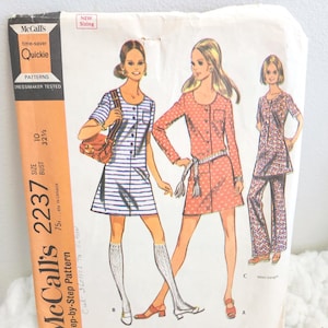 May include: Vintage McCall's 2237 sewing pattern. The pattern features illustrations of dresses and pants in various styles. The package has a white background with illustrations of women wearing the garments. The pattern includes the text "Quickie" and "Misses' and Junior Dress in Two Lengths and Pants."