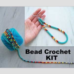 May include: A bead crochet kit with turquoise, black, white, orange, and yellow beads. The kit includes a skein of beads, a finished beaded keychain, and a length of beaded cord.