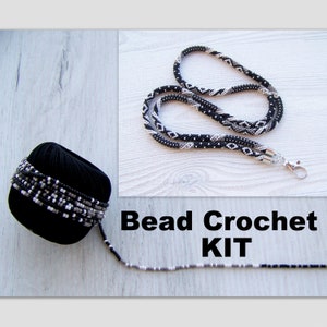 May include: A bead crochet kit with black and white beads. The kit includes a spool of beads, a finished beaded lanyard, and a length of beading thread.