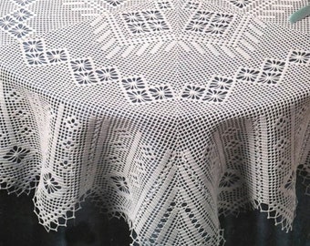 May include: A white crocheted tablecloth with a delicate floral pattern. The tablecloth is round and has a scalloped edge.