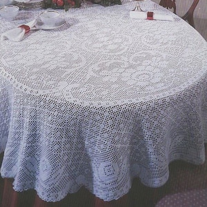 Può includere: Tovaglia all'uncinetto bianca con un delicato motivo floreale. La tovaglia è stesa su un tavolo con due sedie e un centrotavola composto da verde e candele.