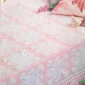 May include: A white crocheted blanket featuring a repeating snowflake pattern across its surface. The blanket is constructed from square motifs joined together and is finished with a decorative fringe along the bottom edge, creating a textured appearance.