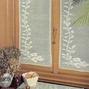 以下が含まれることがあります： 木製のキャビネットに、花柄の白いクロシェカーテンが2枚かけられています。暗い木製のテーブルの上に、花柄の白いクロシェテーブルランナーが置かれています。