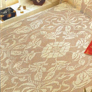 Könnte beinhalten: Cremefarbene, gehäkelte Tagesdecke mit floralem Muster. Das filigrane Design zeigt sich wiederholende Blumen- und Blattmotive, die eine zarte und strukturierte Oberfläche schaffen. Die Tagesdecke ist über ein Bett drapiert und zeigt ihre detaillierte Handwerkskunst und Vintage-Ästhetik.