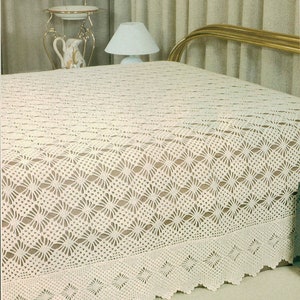 May include: A white crocheted bedspread with a delicate floral pattern. The bedspread has a scalloped edge and is made with a fine yarn.