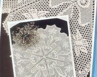 May include: Two white crocheted doilies, one larger than the other, with intricate floral designs. The smaller doily is displayed on a black background, while the larger doily is partially visible in the background.